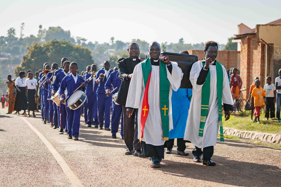 Translators and cousins, Ezekiah Dada and Enos Dada, carry the ark holding the Keliko New Testaments through the streets of Koboko, Uganda.